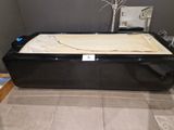a black bath tub with a beige blanket on it