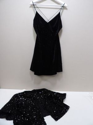 a black dress hanging on a hanger next to a black jacket