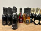 bottles of wine are lined up on a table with a white wall in the background