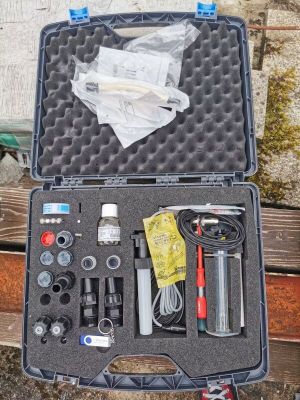 a case with tools in it sitting on a wooden bench