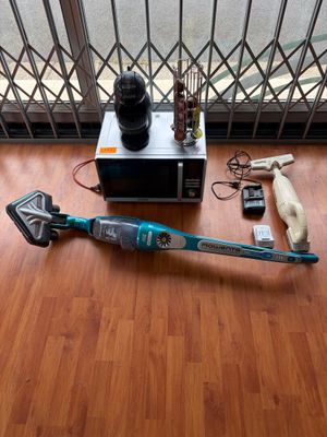 un aspirateur sans fil posé par terre près d'une fenêtre