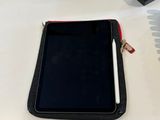 a tablet on a desk with a pen and a cell phone