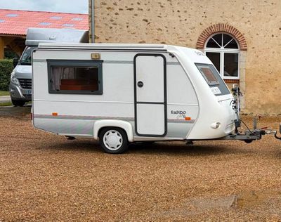 an image of a camper trailer parked in front of a building