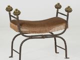 un banc en fer avec une assise marron et un coussin marron posé dessus