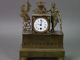 a bronze clock with a statue on top of it