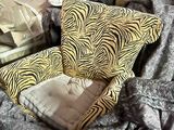 a zebra print chair and pillows on a bed