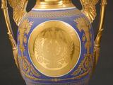 a blue and gold vase with gold decoration on it