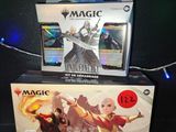 Deux boîtes de « Magic : The Gathering » et une boîte de « Magic : The Gathering » sont posées sur une table.