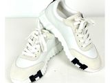 une paire de baskets blanches à semelles noires sur un fond blanc
