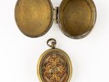 an image of a gold locke with a picture of a flower in it