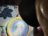 a person looking at a picture of a woman in a gold frame