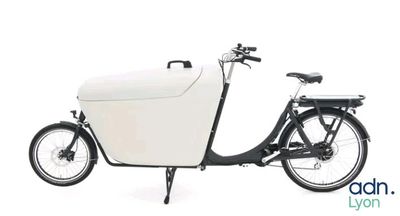 une photo d'un vélo noir et blanc avec un carton blanc à l'arrière