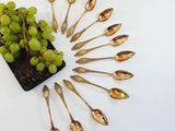 a bunch of gold spoons and a plant in a pot