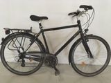 un vélo noir appuyé contre un mur