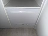 a white dishwasher in the corner of a kitchen