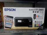 une boîte contenant une imprimante et un téléphone portable, posée sur l'étagère
