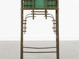 a metal and wood desk with a green glass top