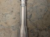 a silver spoon with a spoon handle on a table
