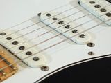 a close up of a black and white electric guitar