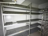 a room with shelves and racks in it that have food on them