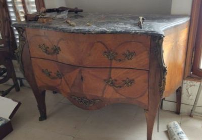 une commode en bois avec un plateau en marbre dans une chambre