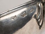 a close up of a silver plate with a handle on it