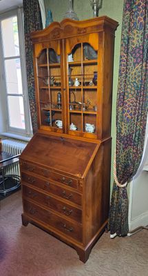 un meuble en bois avec une porte en verre dans une pièce
