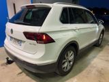 the rear end of a white volkswagen suv parked in a garage