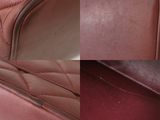a close up of a red leather chair with a quilted seat