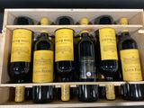 bottles of olive oil in a wooden box on a table