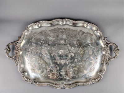 an antique silver plate with a floral design on it