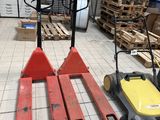 trois palettes posées à même le sol dans un entrepôt