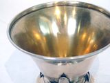a silver bowl sitting on top of a white table