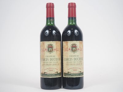 deux bouteilles de vin rouge posées l'une à côté de l'autre sur une surface blanche