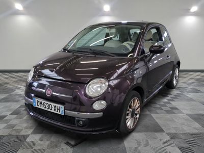 une Fiat violette garée sur un sol à damier dans un showroom