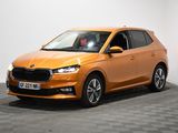 Une voiture orange est garée dans une pièce au sol à carreaux.