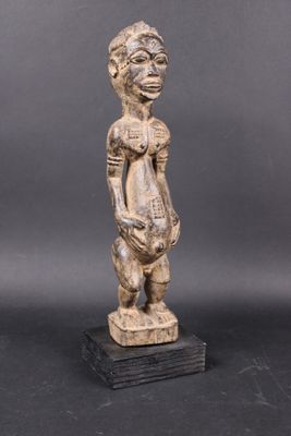 a wooden statue of a woman holding a basket in her hands