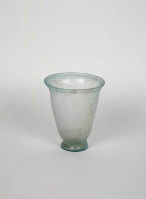 a glass cup that is sitting on a white surface