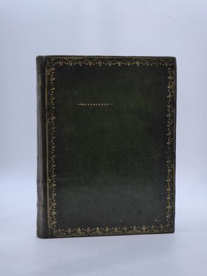 un vieux livre à la couverture noire posé sur une surface blanche