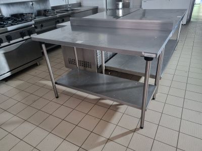 un grand îlot de cuisine en inox au milieu de la cuisine