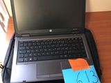 un ordinateur portable posé sur un sac, sur un bureau