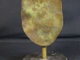 bronze sculpture of a tortoise on a marble base on a black background