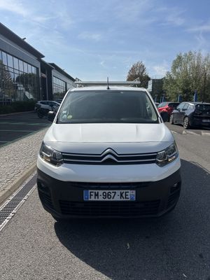 the white van is parked on the side of the road in front of a building