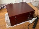 une commode en bois posée sur un parquet en bois massif