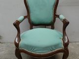 une vieille chaise dont l'assise est recouverte de tissu bleu