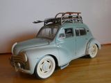 une petite voiture sur laquelle est posée une planche de surf