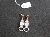 paire de boucles d'oreilles plaquées argent et or rose sur un fond noir