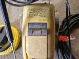 a yellow and black power drill sitting on the floor next to a hose