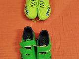 deux paires de chaussures vertes posées sur un lit aux draps orange