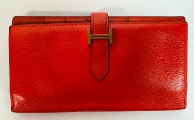 a red leather wallet with a gold clasp on it
